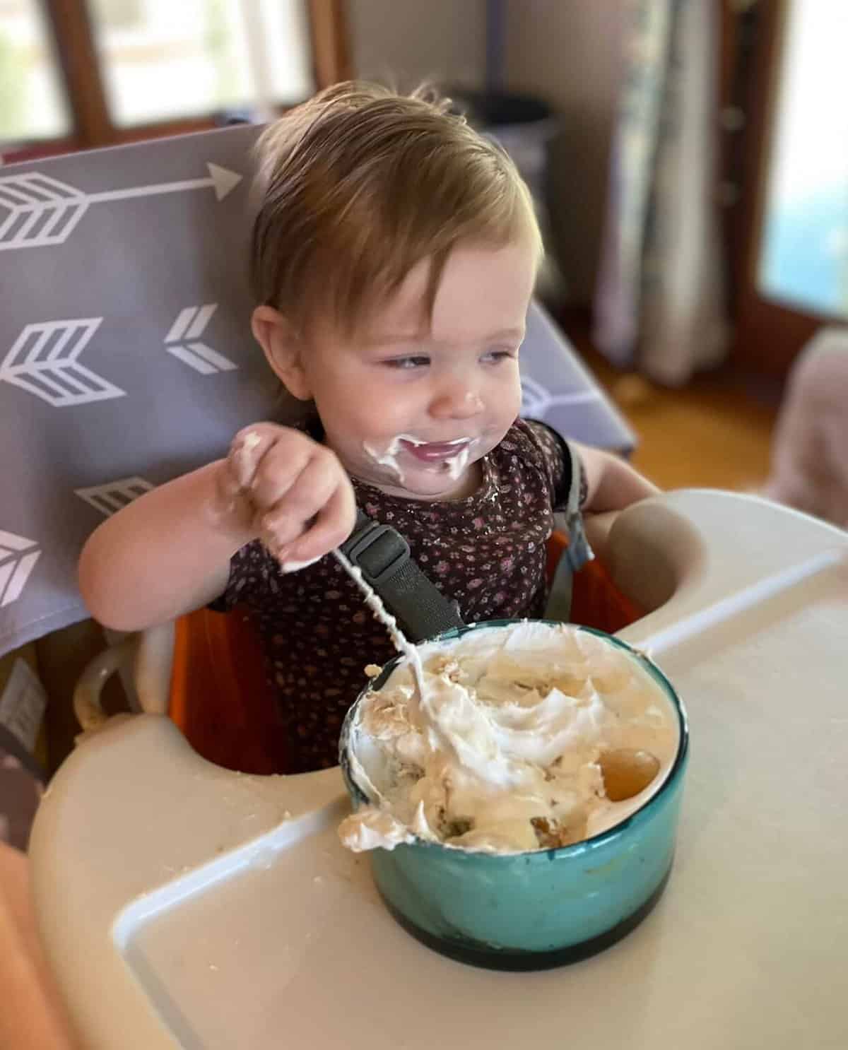 daughters first birthday dessert, eating banana pudding in her high chair.