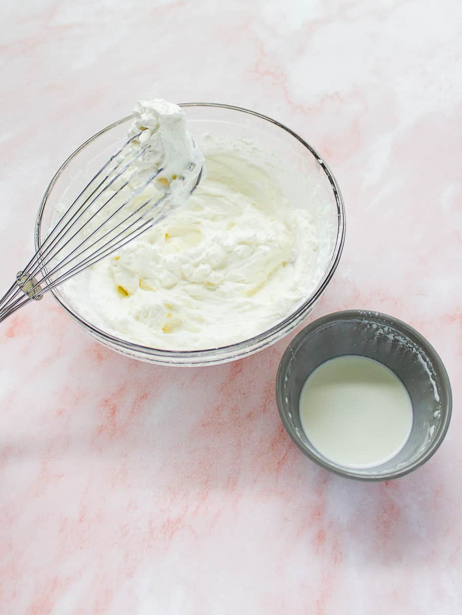 bowl of whipped cream with whisk