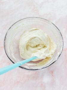 second half of cream mixture folded into cheese mixture in a bowl with rubber spatula