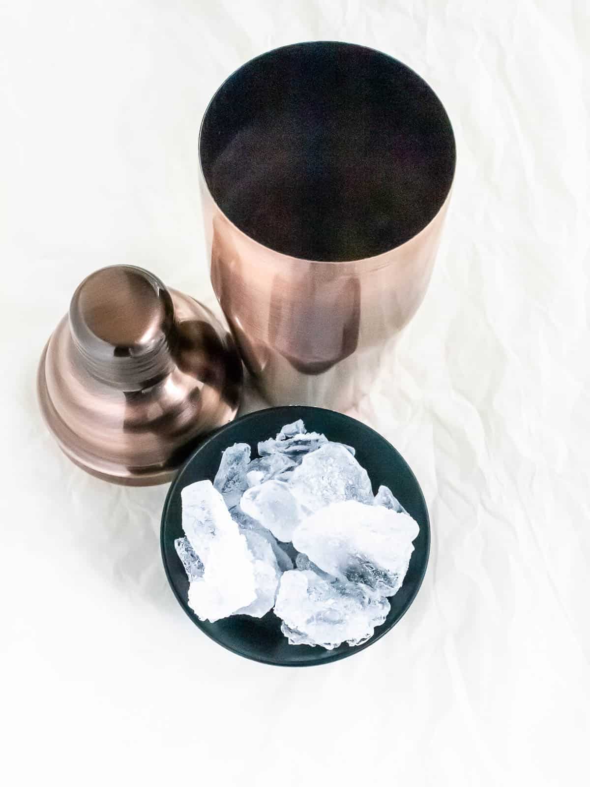 Cocktail shaker with lid and bowl of ice