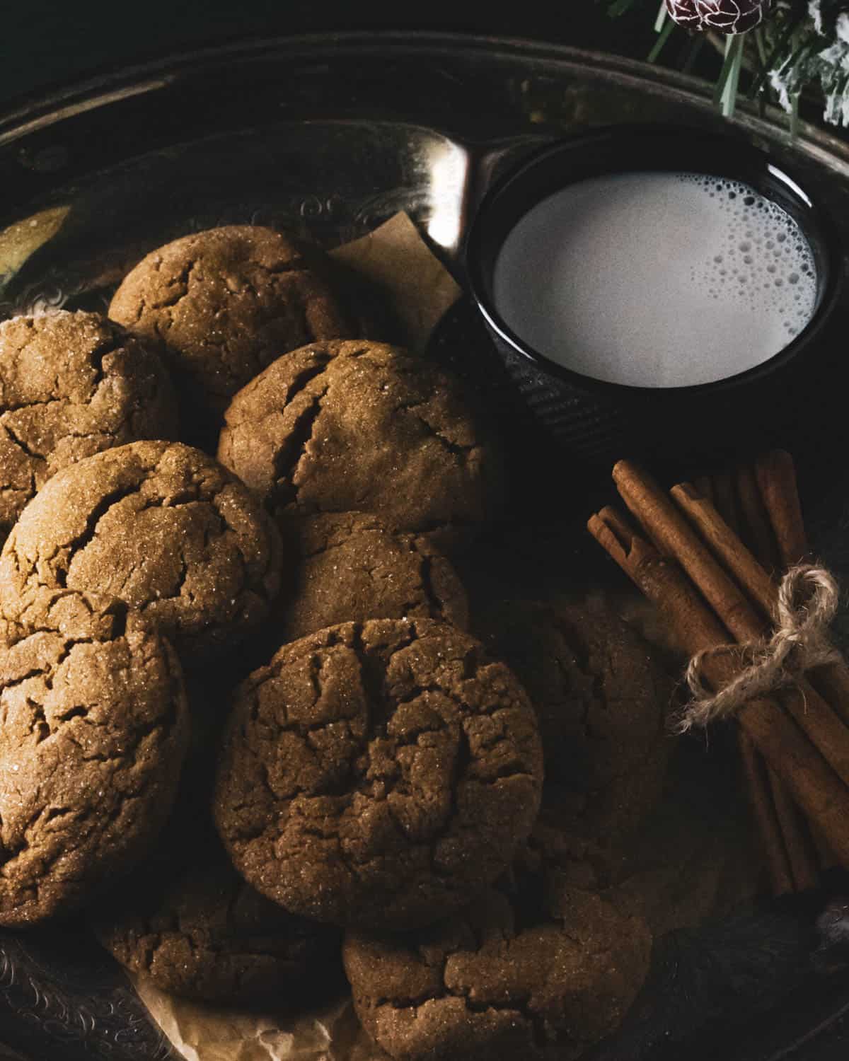 fresh baked gingerbread cookies on a platter with milk