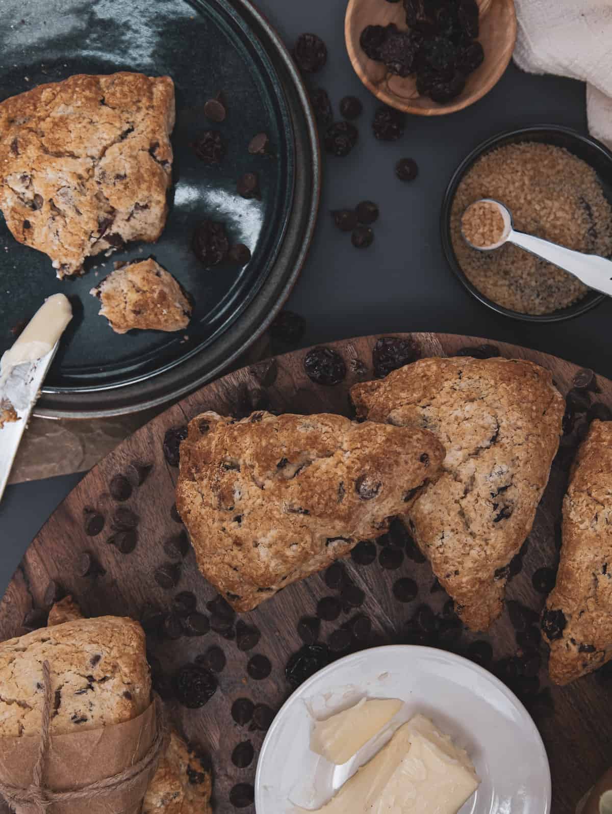 overhead of chocolate cherry scones on a plate with a cup of coffee