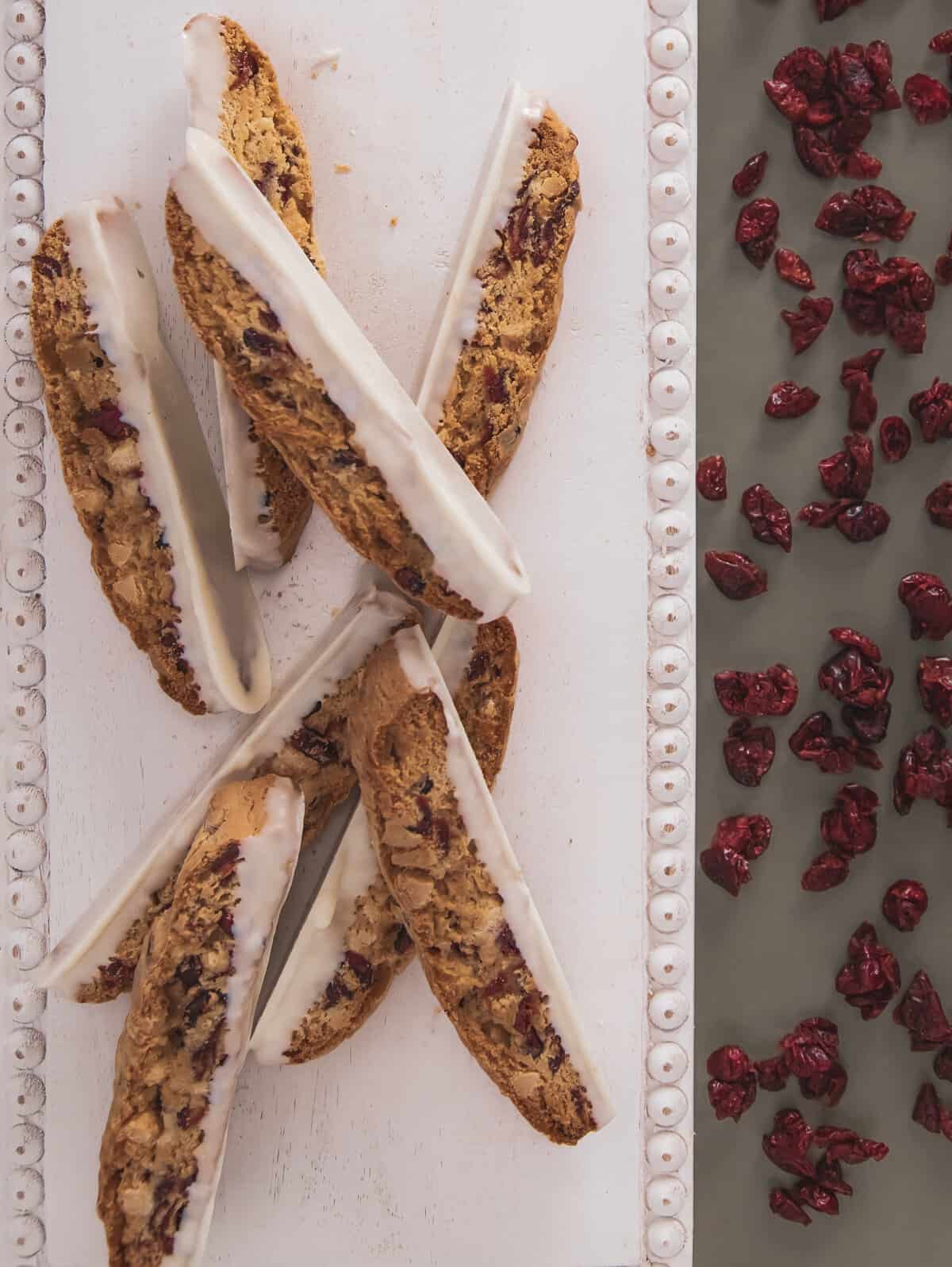 biscotti on a white board next to cranberries