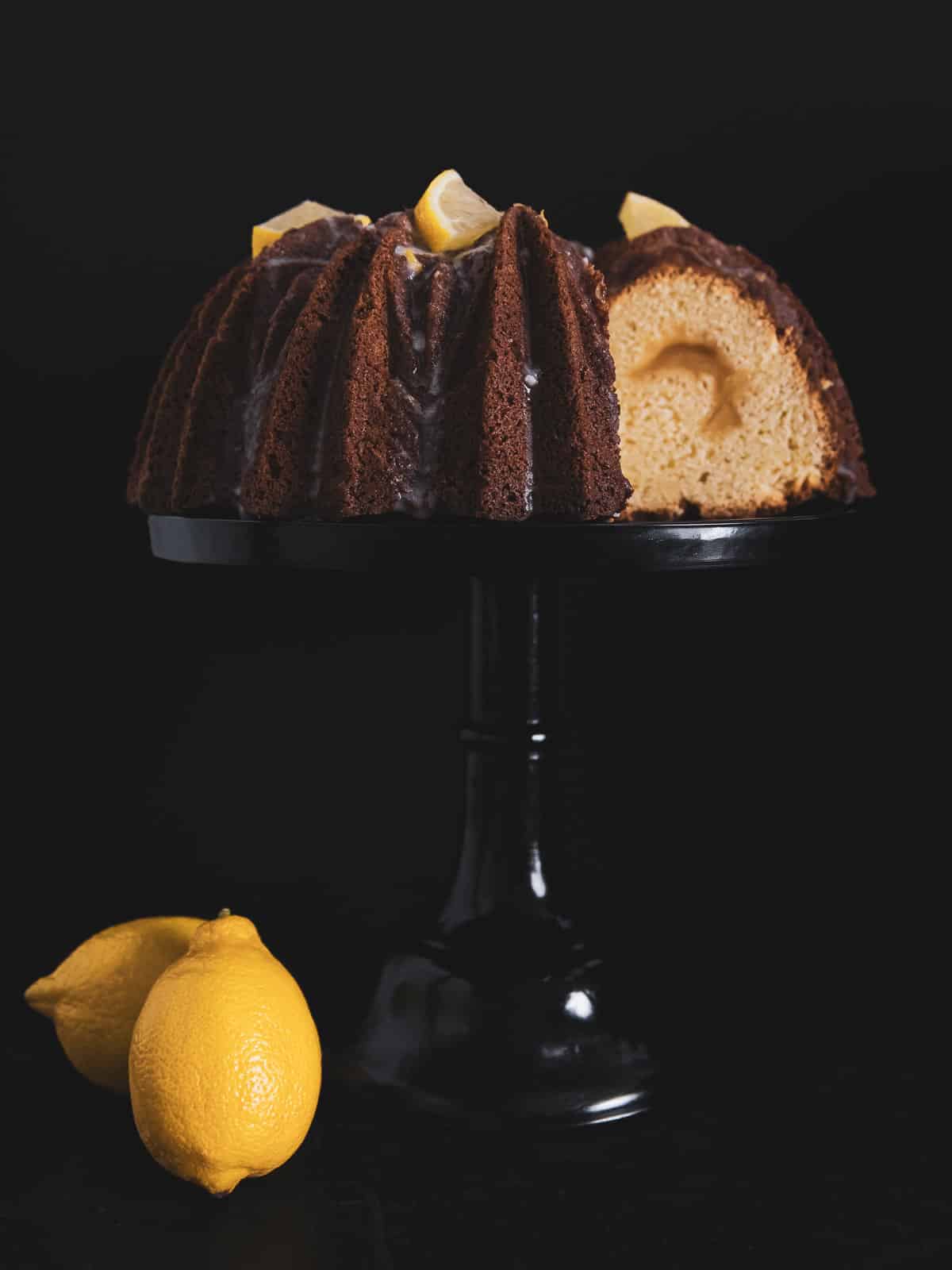 lemon curd cake on a cake stand with a slice taken out