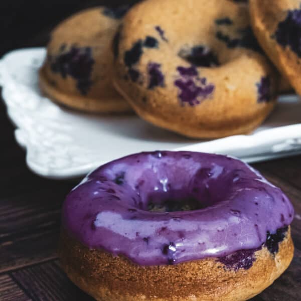 blueberry glazed donut, with unglazed donuts in the back.