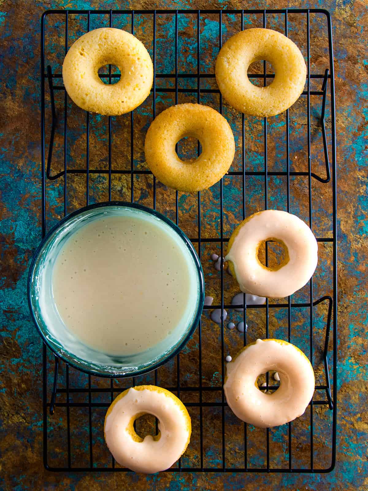 Lemon donuts being dipped into the lemon glaze.
